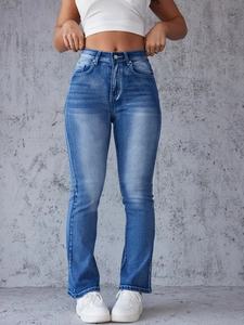 Detail of high waisted flared jeans with vintage wash and whiskers on blue denim fabric