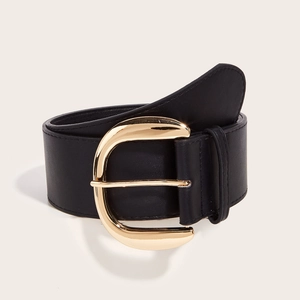 Close-up of black leather wide belt featuring a polished gold horseshoe buckle detail