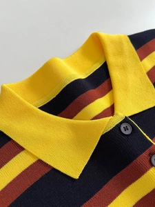 Detail of knit polo shirt showing yellow ribbed collar and striped texture with buttons