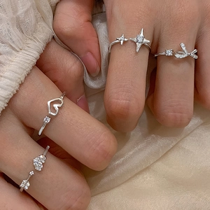 Elegant silver bow and heart rings with sparkling crystals shown on a model's hand