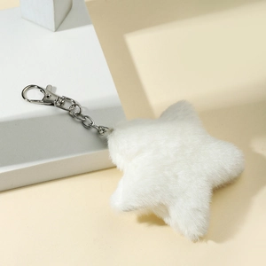 Plush white star keychain with silver metal clip on a minimalist display stand