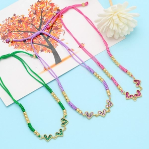 Detail of adjustable handmade woven bracelets with colorful heart-shaped zircon pendants