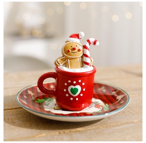 Close-up of Christmas gingerbread figurine in red cup on a plaid wooden tray