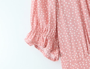 Detail of pink polka dot lace dress featuring ruffled elastic cuffs and breathable fabric