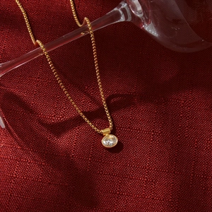 Dettaglio della collana in acciaio al titanio dorato con ciondolo in zircone rotondo