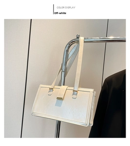 Detail of cream white leather shoulder bag featuring natural texture and gold metal buckle