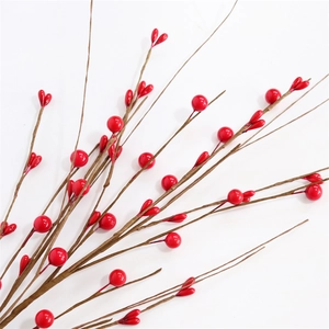 Detailed close-up of glossy red artificial berries with round and heart shapes for decor