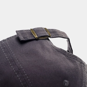 Detail of adjustable metal buckle and cotton twill strap on charcoal baseball cap