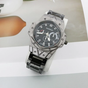Macro shot of silver alloy watch case with black dial and protective film on metal band