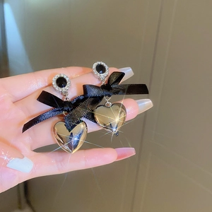 Detail of velvet heart earrings with black bow, crystal inlay and silver pendant