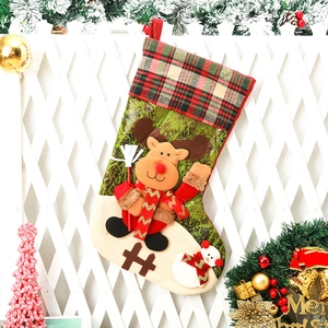 Kerstsok met elandpop en rood ruitpatroon hangend aan een wit hekwerk decor