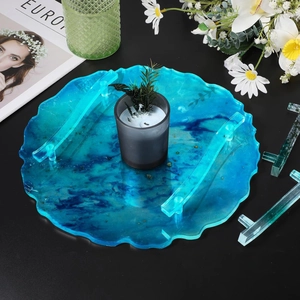 Detail view of a wavy-edged blue resin tray with ink-wash pattern and clear handles