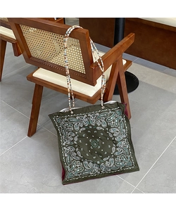 Detail of paisley print tote bag in dark green fabric with a colorful beaded strap