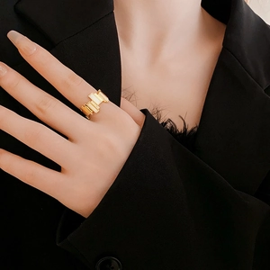 Detail shot of a gold-plated geometric ring with white rectangular mother of pearl inlay