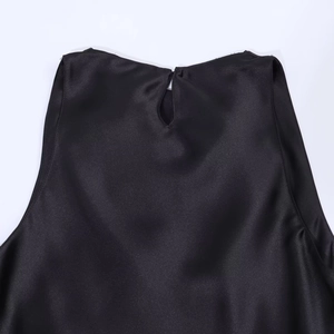 Detail of the back neck closure with a cutout button on a black satin evening dress