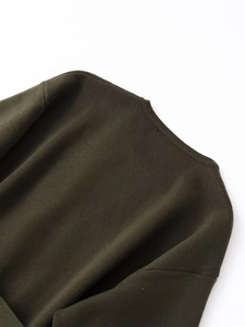 Gros plan détaillé sur la maille vert olive foncé et l'encolure de ce cardigan élégant