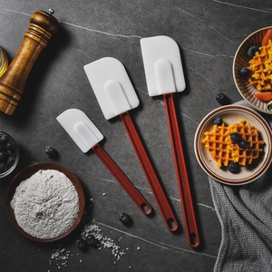 3-piece heat-resistant silicone cream spatula set with red handles on marble surface