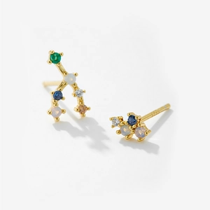 Detailed macro of asymmetric S925 silver earrings with colorful zircons and gold plating