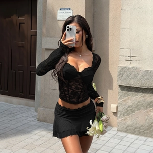 Detailed view of black lace long sleeve top and pleated mini skirt set with street style