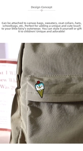 Cute enamel ice cream penguin brooch pinned on a khaki canvas backpack detail