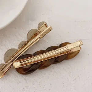 Set of minimalist Korean-style hair clips with grey resin and amber chain designs