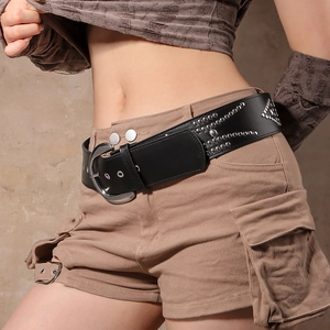 Macro shot of black vintage leather belt with silver rivets and buckle on khaki pants