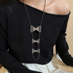 Detail of multi-layered bowknot pendant necklace with sparkling rhinestones on model