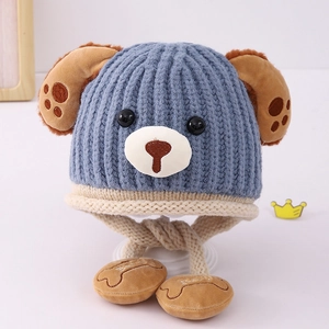 Close-up of blue striped baby knit hat with puppy ears and Baby embroidered charms