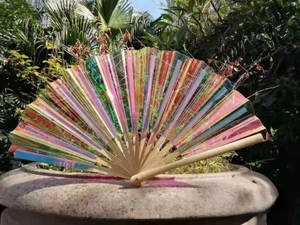 Macro detail of iridescent laser PVC kung fu fan with light natural bamboo ribs