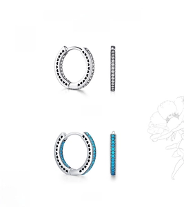 Detail view of 925 sterling silver hoop earrings with hollow heart design and blue stones