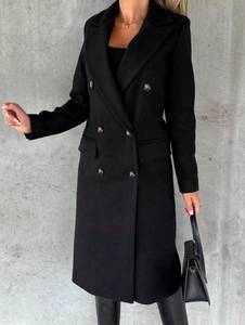 Detail of black double-breasted long coat with lapel collar and side pockets