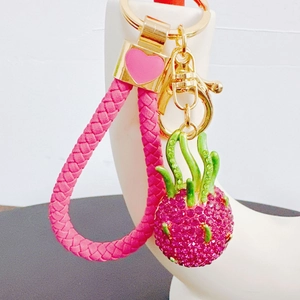 Sparkling pink rhinestone dragon fruit keychain with gold hardware and woven lanyard