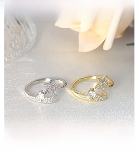 Macro shot of silver and gold star rings with micro-inlaid stones and open design