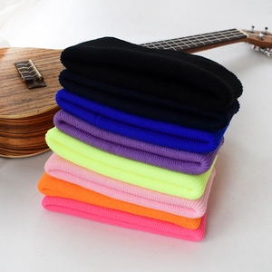 Détails de la texture tricotée de divers bonnets colorés sur fond blanc pur