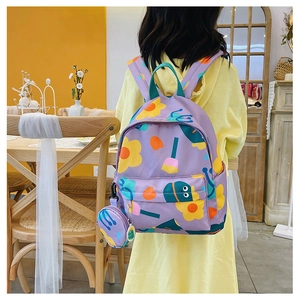 Close-up of a purple floral kids backpack with a matching round coin purse pendant