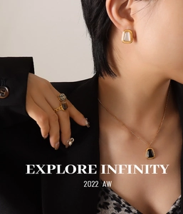 Close-up of model wearing gold square onyx necklace and white shell earrings set