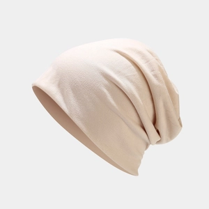 Gros plan du bonnet beige souple montrant la texture du tricot et la fluidité du tissu