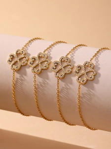 Close-up of golden four-leaf clover bracelets with 5A cubic zirconia on display stand