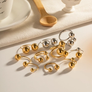 Minimalist spherical gold and silver metal rings and earrings with mirror finish