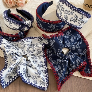 Detailed view of floral fabric headbands featuring vintage navy blue patterns and hand-stitched edges