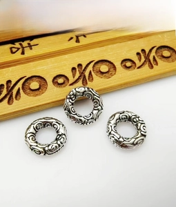 Macro detail of three antique silver cloud pattern spacer beads for DIY jewelry making