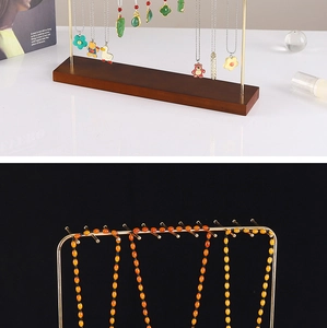 Detail of golden metal hooks and solid wood base for necklace and jewelry storage stand