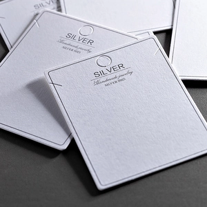 Macro shot of white S925 Silver jewelry display cards with handmade text and hanging holes