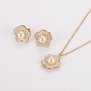 Detaillierte Nahaufnahme von goldenen Blumenohrringen und Halskette mit Perlen und Kristallen