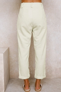 Detail der cremefarbenen Cord-Struktur und Rückansicht der hohen Taille der Damenhose