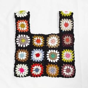 Close-up of handmade crochet tote bag featuring colorful granny square floral patterns