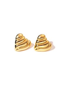 Detail view of gold heart stud earrings featuring a textured ribbed design and metallic finish