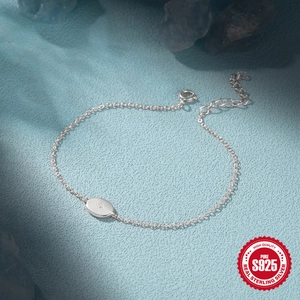 Minimalist S925 sterling silver bracelet with oval pendant on blue textured surface