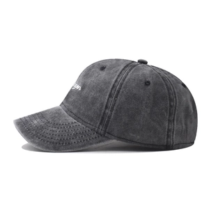 Detailed side view of washed dark grey cotton baseball cap with white script embroidery