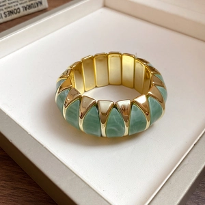 Detail of square acrylic marble green and gold metal segments on elastic bracelet